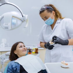 dentysta pokazuje jak dbać o implanty zębów po zabiegu wszczepienia