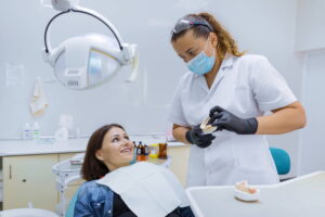 dentysta pokazuje jak dbać o implanty zębów po zabiegu wszczepienia
